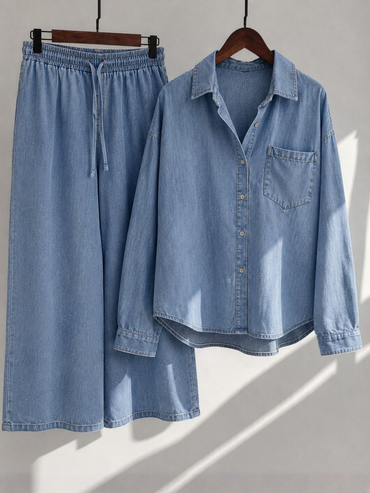 Elara Muse light blue denim button-down shirt and wide-leg palazzo displayed on wooden hangers